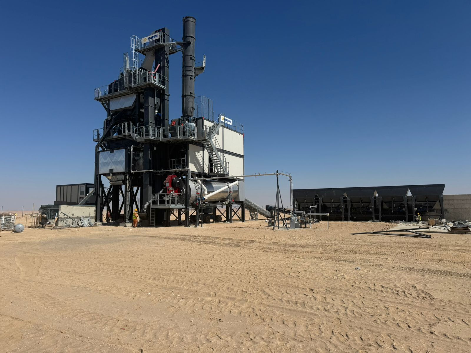 Rawasi asphalt plant in the Omani desert — production tower, chimney stack, mixing drum and cold-feed bins